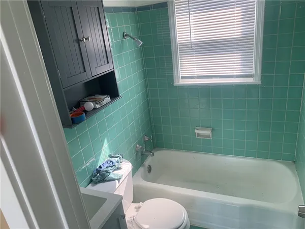 a bathroom with a sink a toilet a bathtub and window