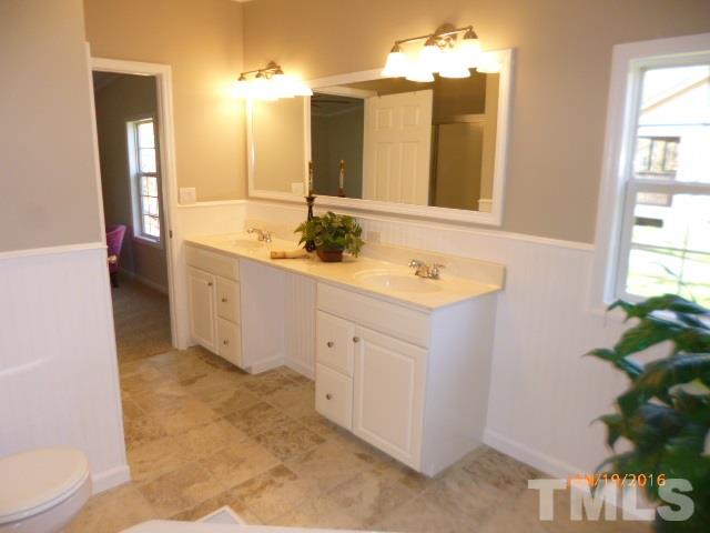 523 Poplar Springs Church Road Raleigh, NC 27603 - Photo 10 of 24 a spacious bathroom with a granite countertop sink and a mirror