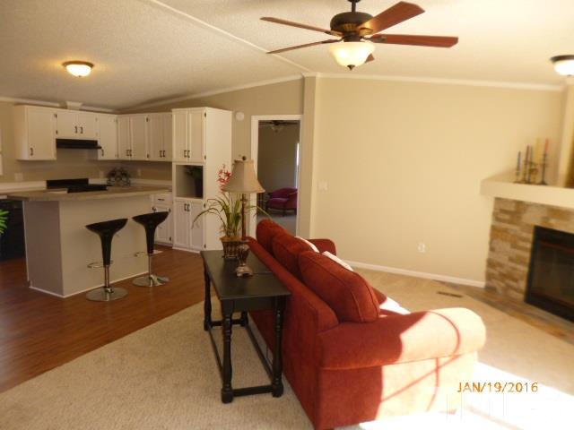 523 Poplar Springs Church Road Raleigh, NC 27603 - Photo 5 of 24 a living room with furniture a fireplace and a flat screen tv