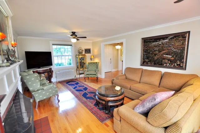 a living room with furniture a flat screen tv and kitchen view