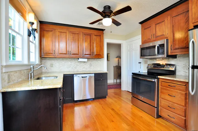a kitchen with stainless steel appliances granite countertop a sink a stove and a refrigerator