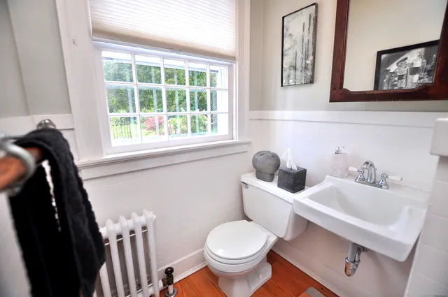 a bathroom with a toilet a sink and a mirror