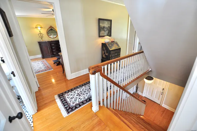 a view of staircase with railing and a rug
