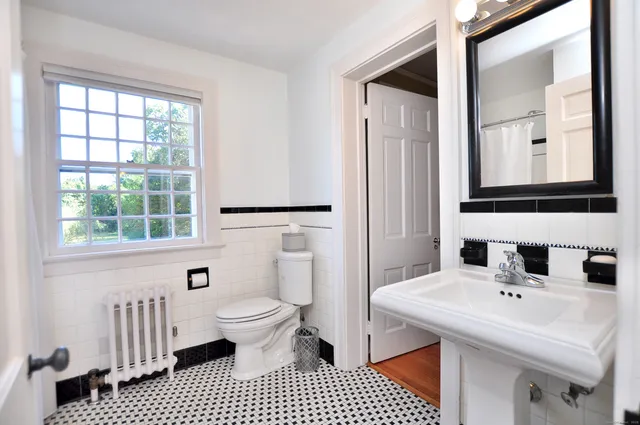 a bathroom with a sink toilet a mirror and shower