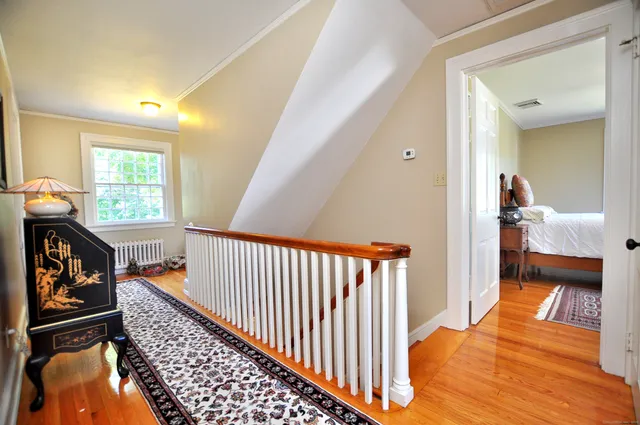 a view of hallway with wooden floor and stairs
