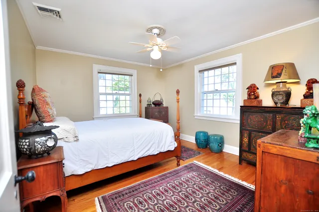 a bedroom with a bed and wooden floor