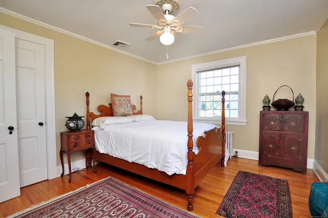 a bedroom with a bed and wooden floor