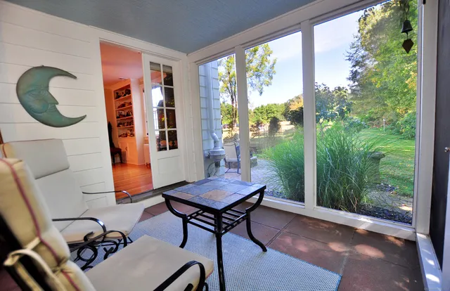 a view of a house with a yard and large tree