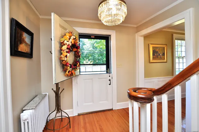 a view of a hallway with wooden floor and staircase