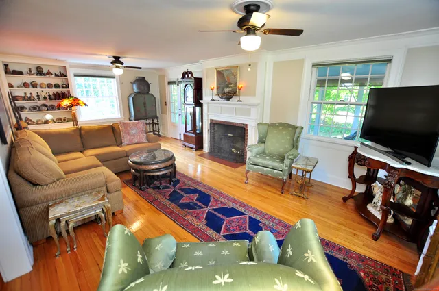 a living room with furniture a flat screen tv and a fireplace