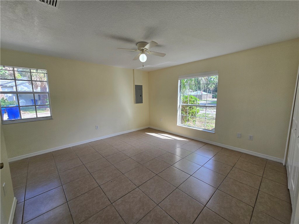 1748 23rd Street Vero Beach, FL 32960 - Photo 7 of 10 an empty room with windows and chandelier fan
