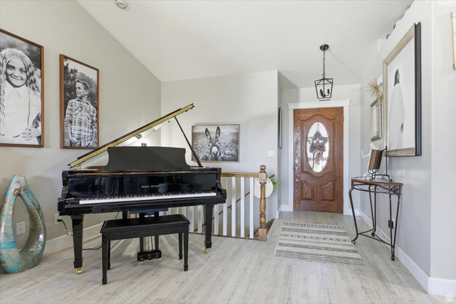 772 East 600 South Preston, ID 83263 - Photo 7 of 35 Foyer featuring wood-finish flooring, a wood entry door with an oval glass insert, a black lantern-style pendant light, and a white staircase with a wood railing