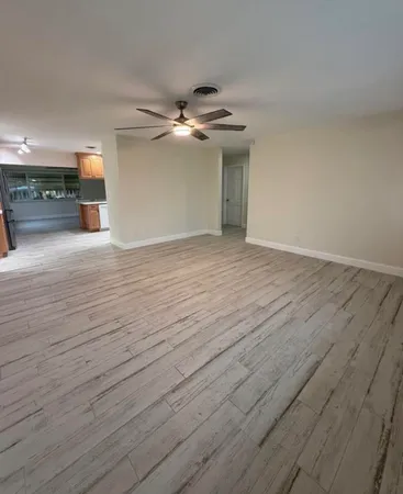 a view of empty room with wooden floor