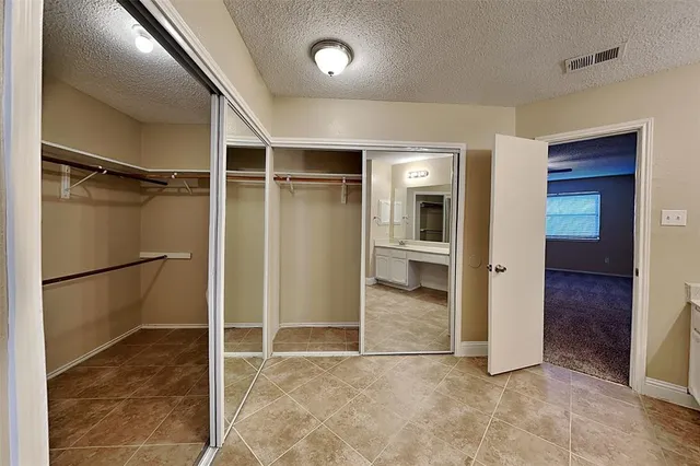 a spacious bathroom with a double vanity sink a large mirror and shower