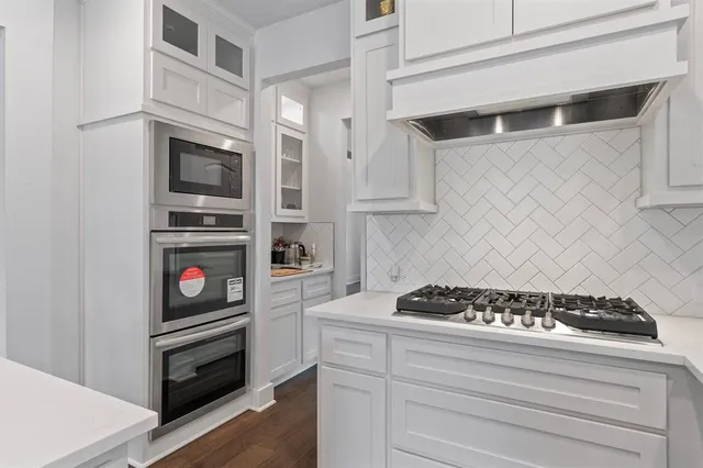 a kitchen with stainless steel appliances granite countertop white cabinets and a stove