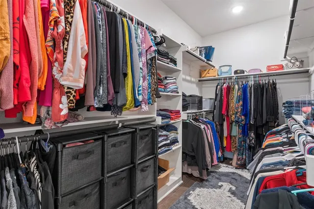 a view of walk in closet with clothes