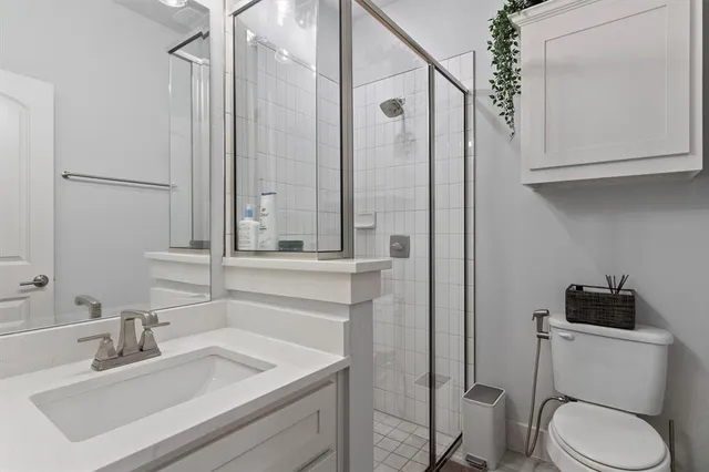 a bathroom with a sink toilet vanity and shower