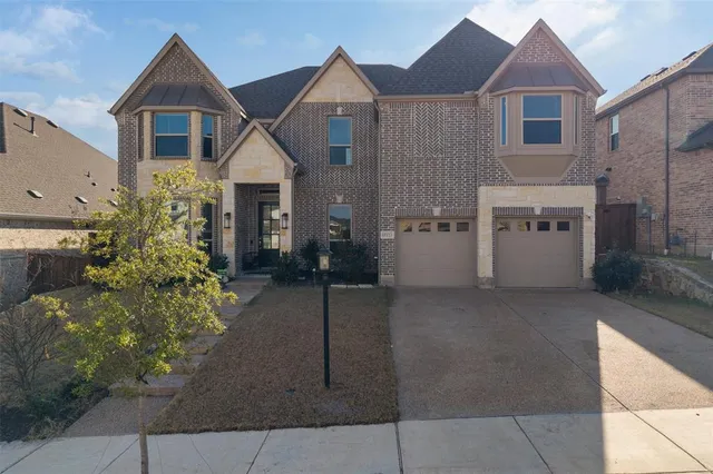 a view of a house with brick walls and a yard