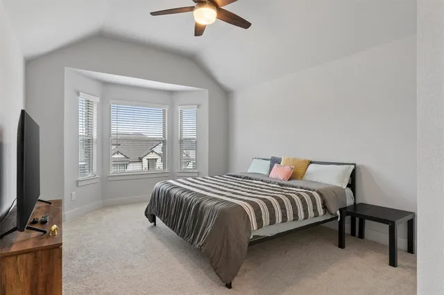a bedroom with a bed flat screen tv and a chandelier