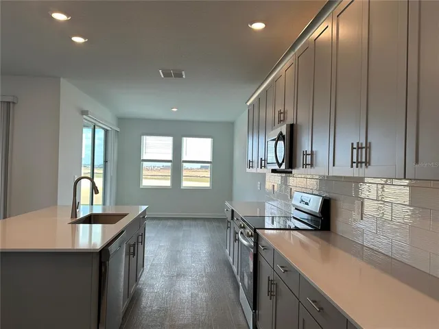 a kitchen with stainless steel appliances granite countertop a sink stove and refrigerator