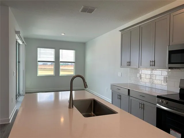 a kitchen with granite countertop a sink and a stove top oven