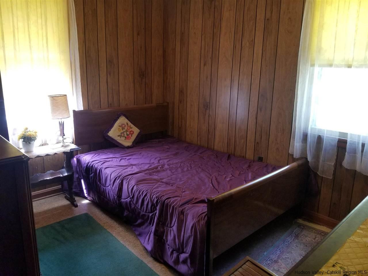 545 Upper Cherrytown Road Kerhonkson, NY 12446 - Photo 28 of 35 a bed sitting in a bedroom next to a window