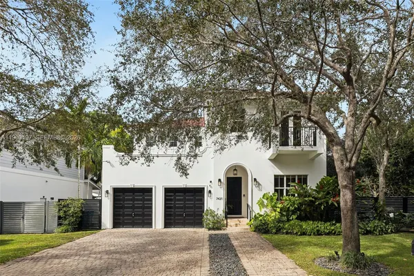 a view of white house with a yard and plants