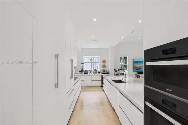 a large white kitchen with stainless steel appliances