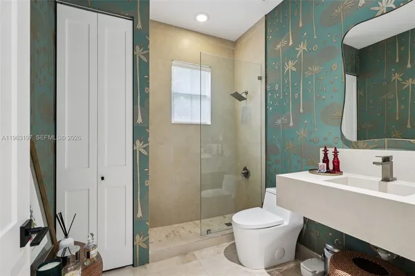 a bathroom with a sink a toilet and shower