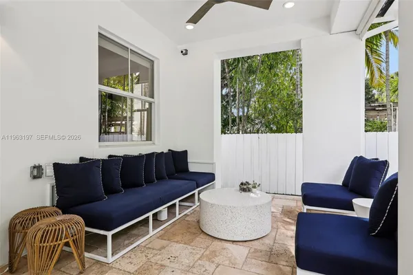a view of a white house with large windows and a table and chairs