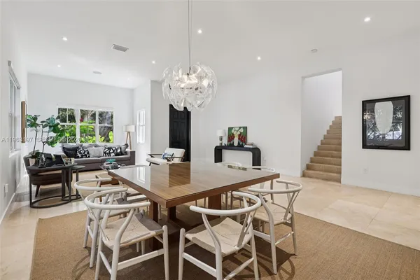 a view of a dining room with furniture a chandelier and wooden floor