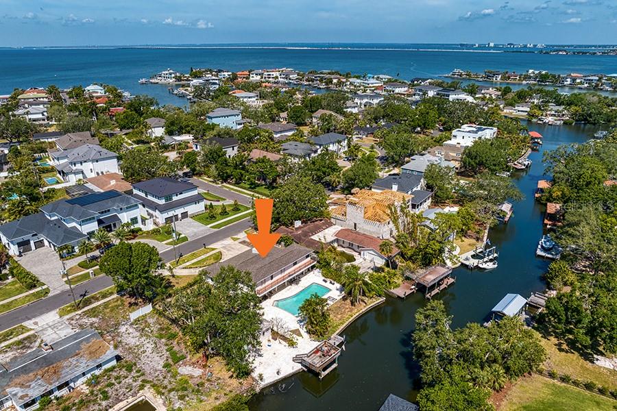 an aerial view of ocean and residential houses with outdoor space