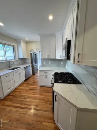 a kitchen with granite countertop a sink a stove and refrigerator