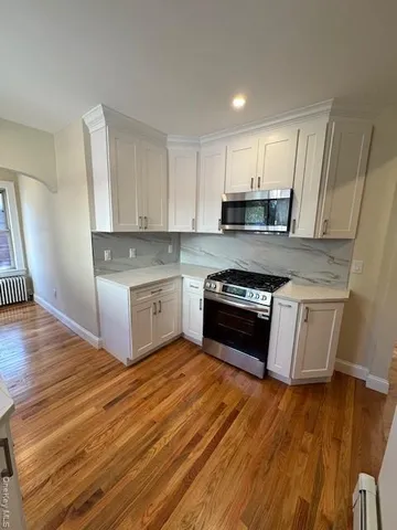 a kitchen with wooden floors and white appliances