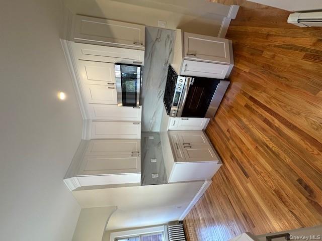 39 Ward Street, Unit 1 Floral Park, NY 11001 - Photo 4 of 11 a kitchen with wooden floors and white appliances