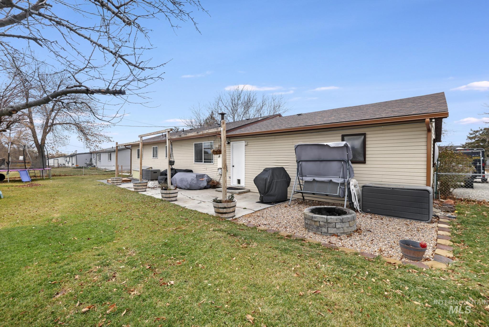 3083 Dickson Avenue Twin Falls, ID 83301 - Photo 21 of 26 Back of house featuring a fenced backyard, a patio area, a shingled roof, and a trampoline