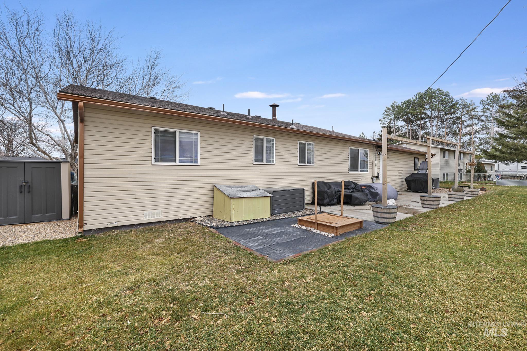 3083 Dickson Avenue Twin Falls, ID 83301 - Photo 23 of 26 Back of house with a storage shed, a patio, a lawn, and a deck