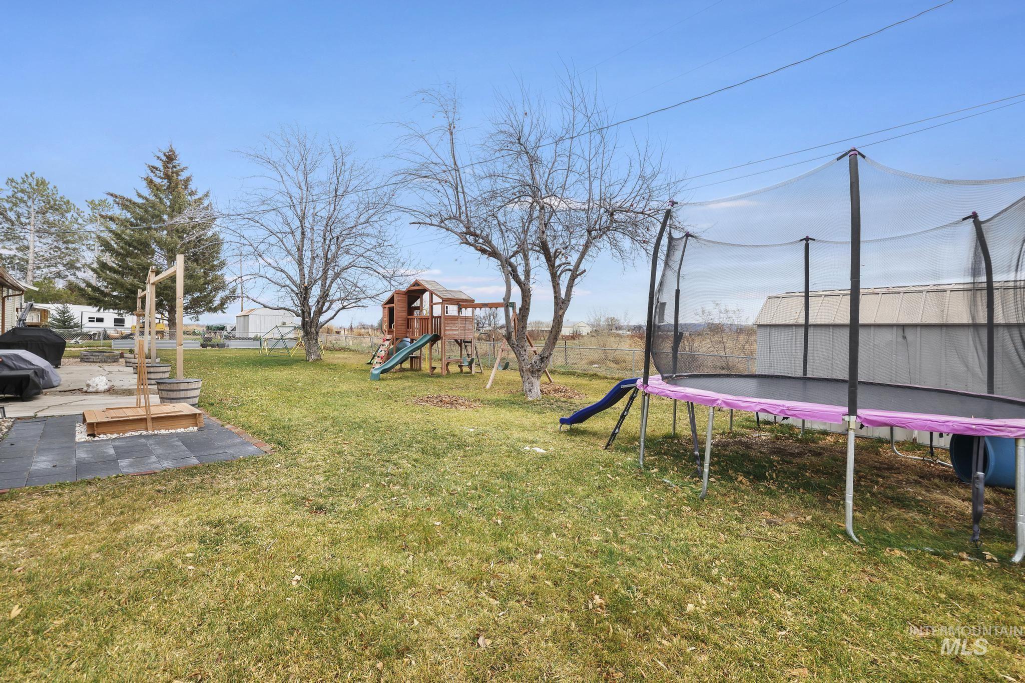 3083 Dickson Avenue Twin Falls, ID 83301 - Photo 24 of 26 Fenced yard with a trampoline, a playground, and a patio