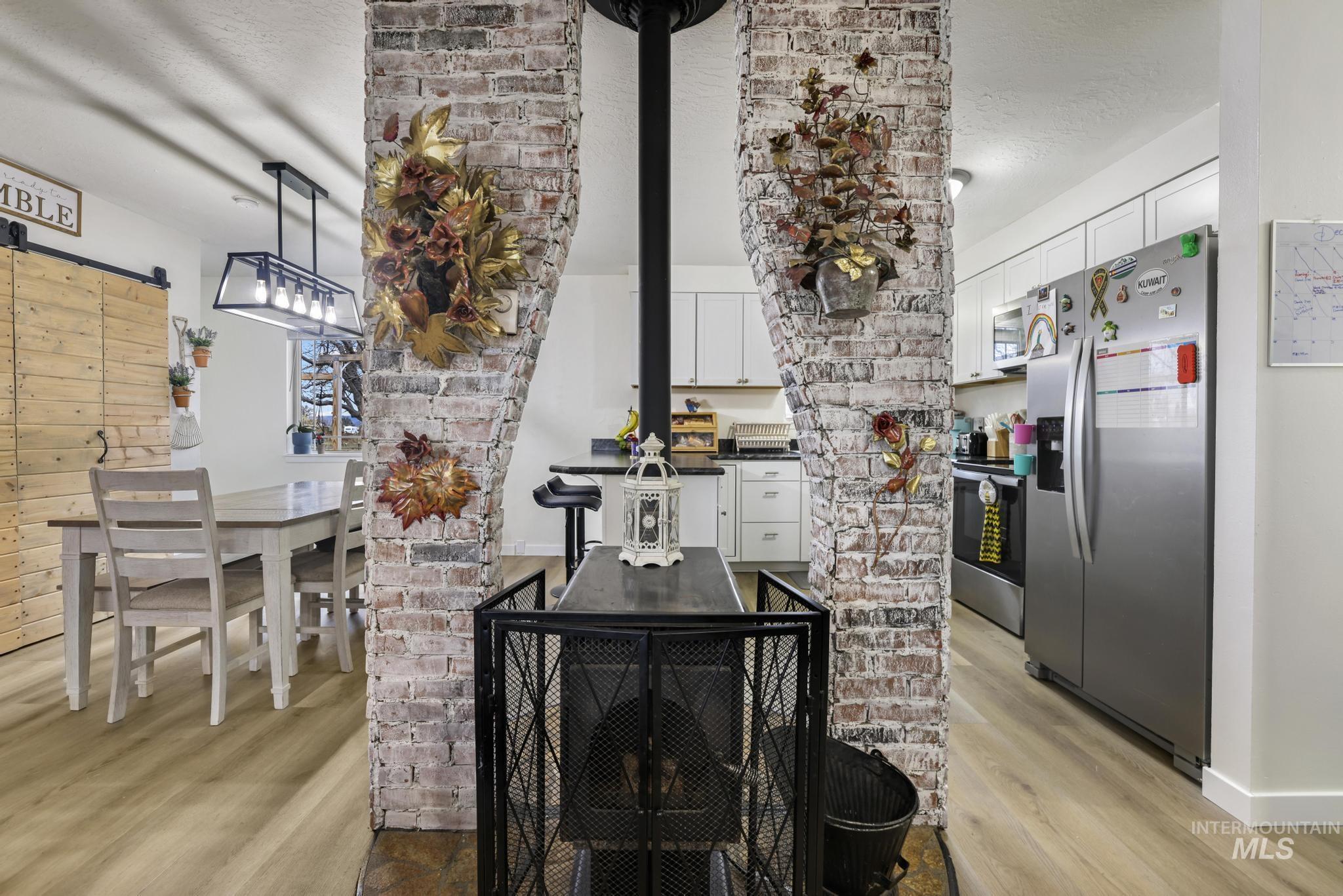 3083 Dickson Avenue Twin Falls, ID 83301 - Photo 5 of 26 Detailed view of stainless steel appliances, wood finished floors, a barn door, and a textured ceiling