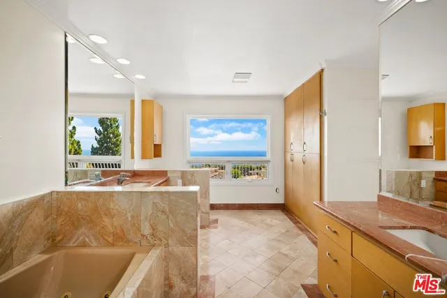 a spacious bathroom with a granite countertop tub sink and mirror