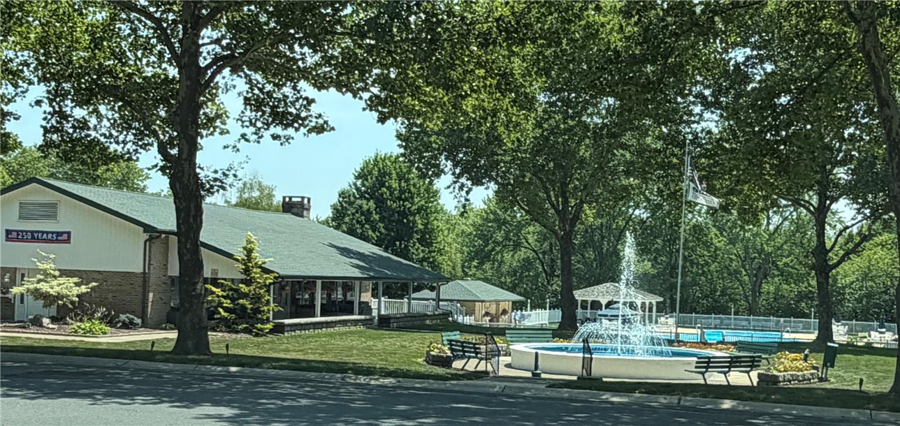12 Springridge Road Bath, PA 18014 - Photo 69 of 70 A vibrant fountain with an elegant gazebo offers a serene setting alongside a charming building, all nestled within mature trees.
