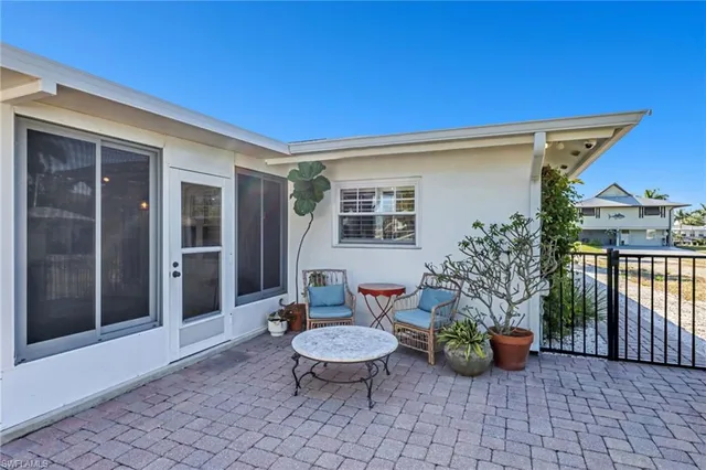 a view of a patio with couple of chairs and a potted plant