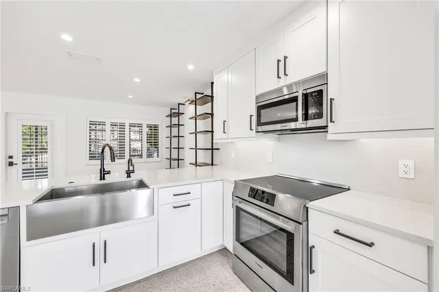a kitchen with white cabinets stainless steel appliances and sink