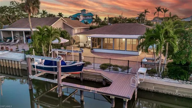 a front view of a house with a yard and potted plants