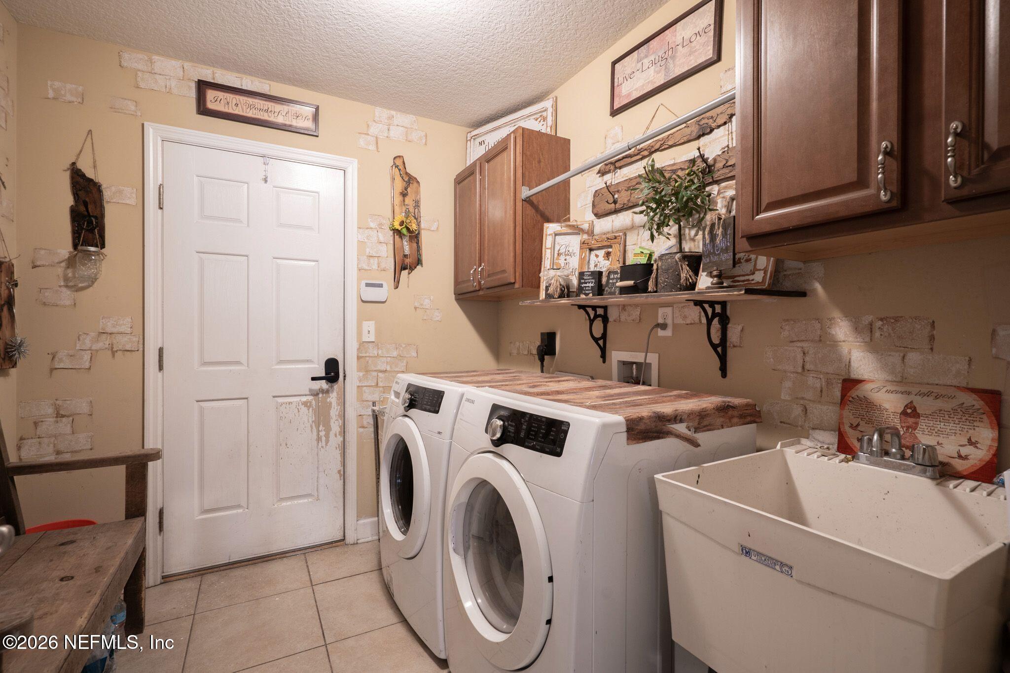 97447 Bluff View Circle Yulee, FL 32097 - Photo 12 of 19 a view of washer and dryer with kitchen in the background
