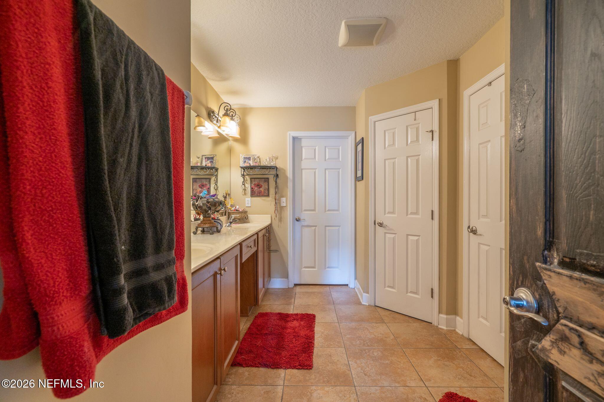 97447 Bluff View Circle Yulee, FL 32097 - Photo 15 of 19 a bathroom with a tub sink vanity and a mirror