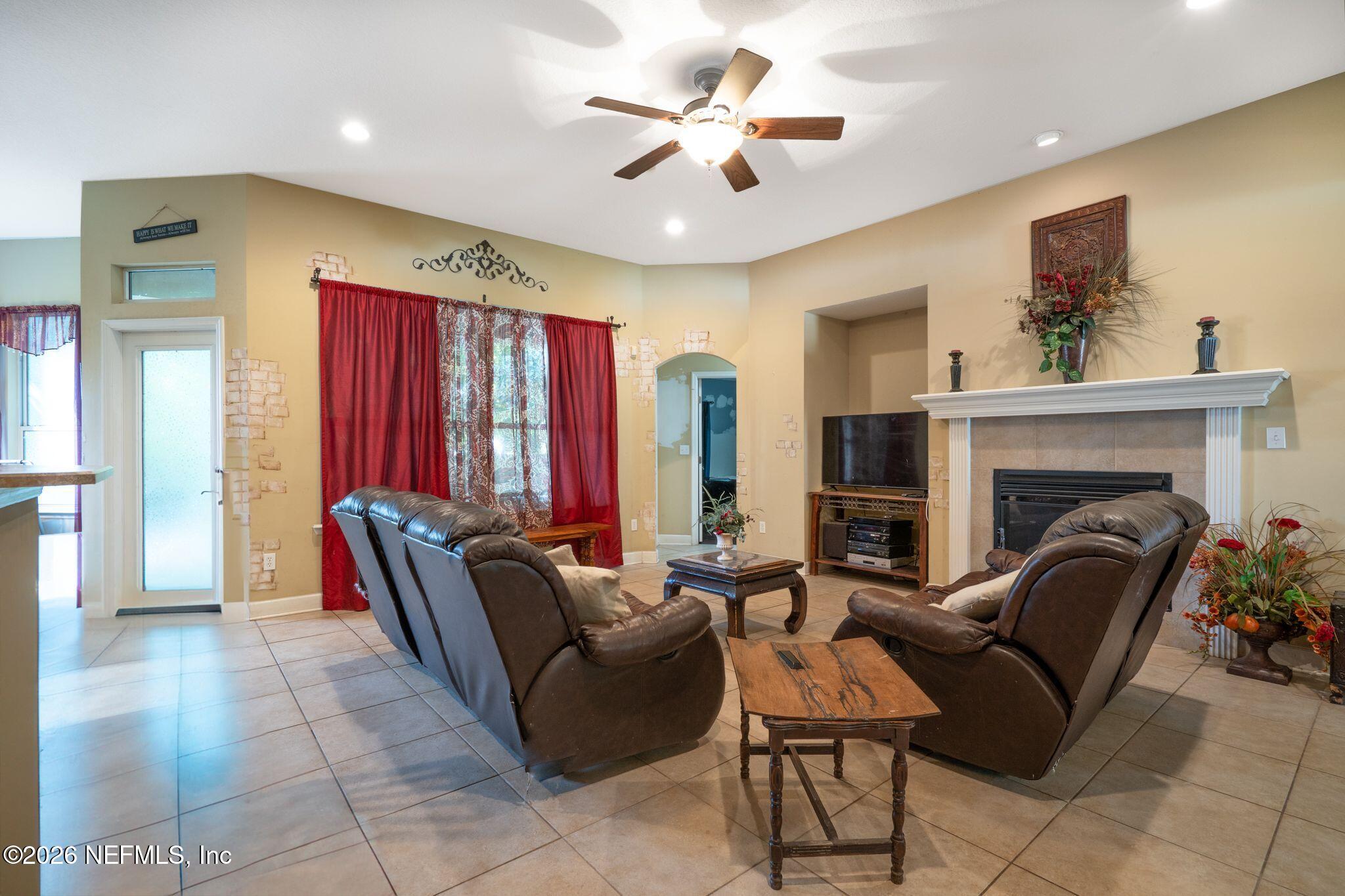 97447 Bluff View Circle Yulee, FL 32097 - Photo 7 of 19 a living room with furniture a fireplace and a chandelier