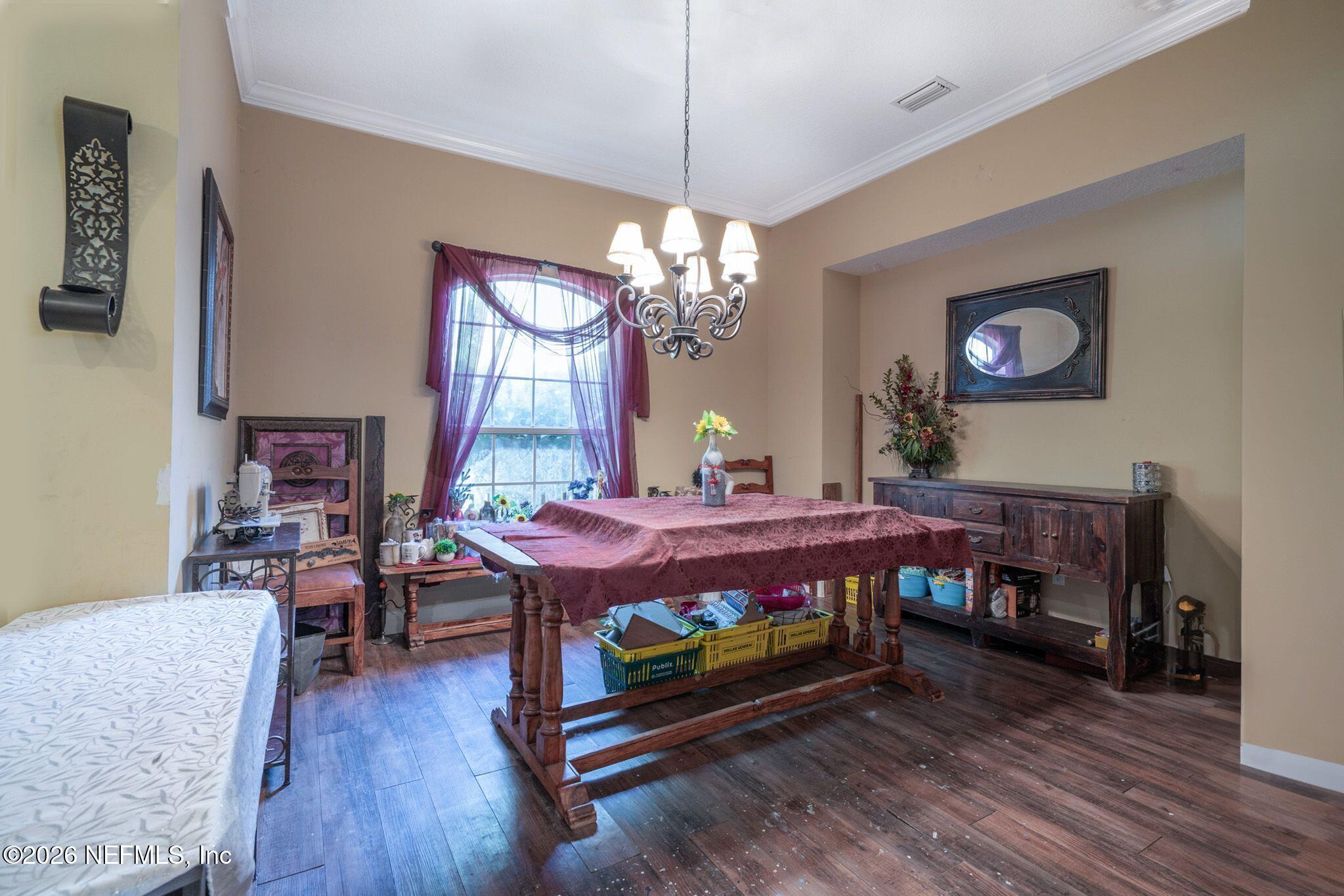 97447 Bluff View Circle Yulee, FL 32097 - Photo 8 of 19 a dining room with furniture a chandelier and wooden floor