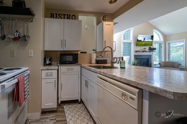 a kitchen with stainless steel appliances granite countertop a sink a stove and cabinets