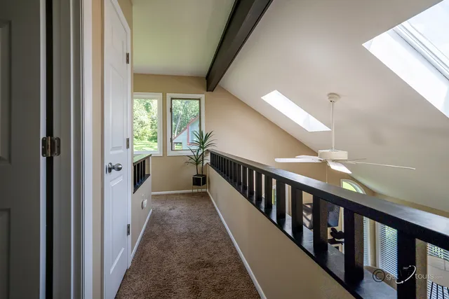 a view of a hallway with wooden floor and stairs